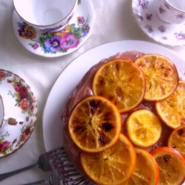 A vegan cake with orange slices on it.