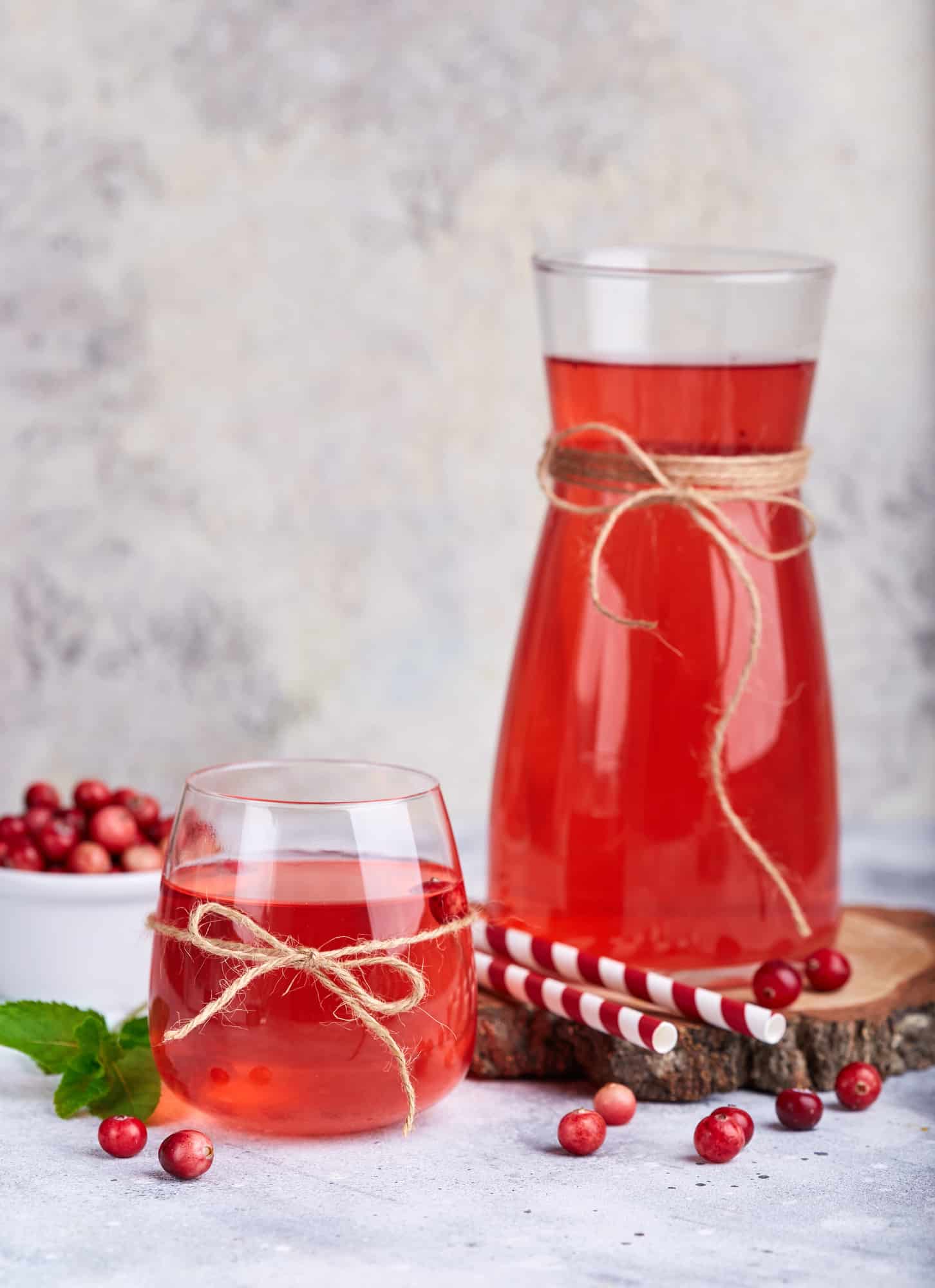 A glass and bottle of cranberry mors.