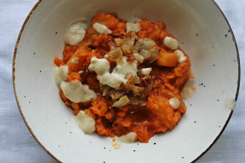 Red lentil stew with crema and onions