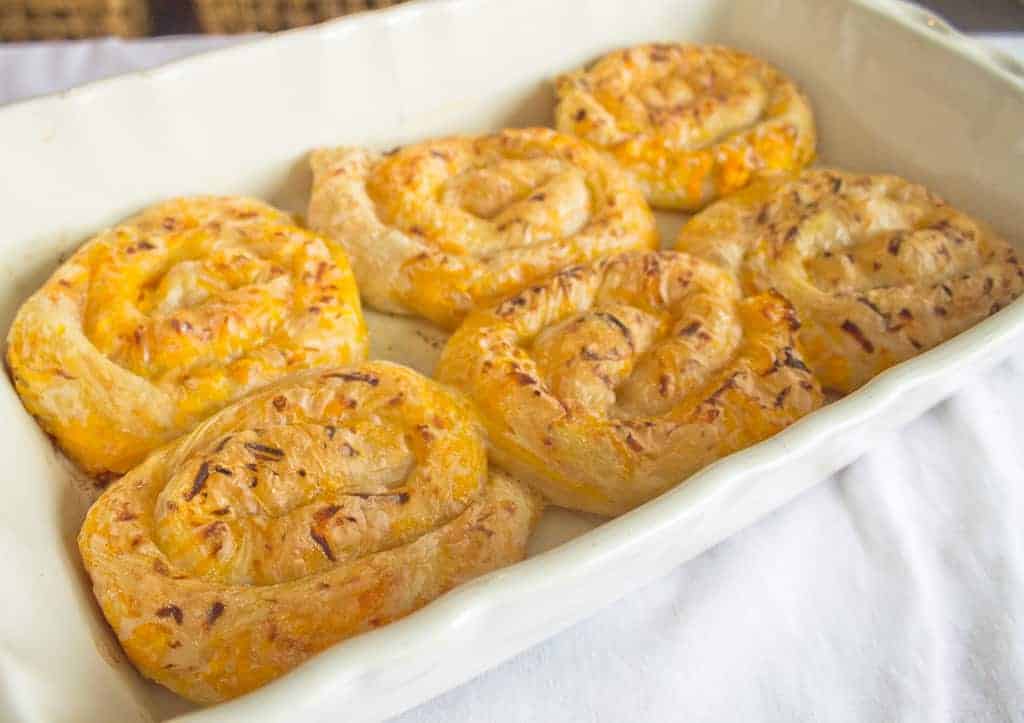 Cheesy cinnamon rolls in a white baking dish.