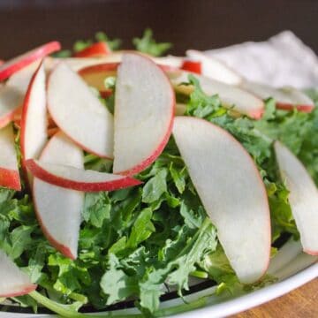 Side view of the apple and greens salad in a plate.