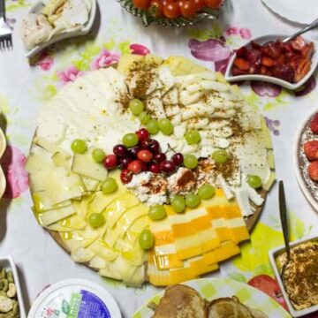 Plate with a cheese platter among assorted dishes on table