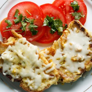 French toast grenki with cheese and tomatoes on a plate.