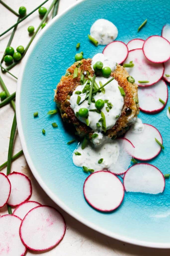 Quinoa fritters with peas, feta and yogurt-herb sauce are everything that will make you fall in love with this gluten-free, energy-filled seed. Make them bigger for great veggie burger patties! #glutenfree and #vegetarian