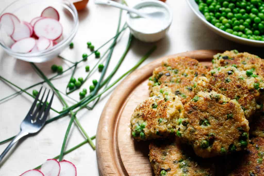 Quinoa fritters with peas, feta and yogurt-herb sauce are everything that will make you fall in love with this gluten-free, energy-filled seed. Make them bigger for great veggie burger patties! #glutenfree and #vegetarian