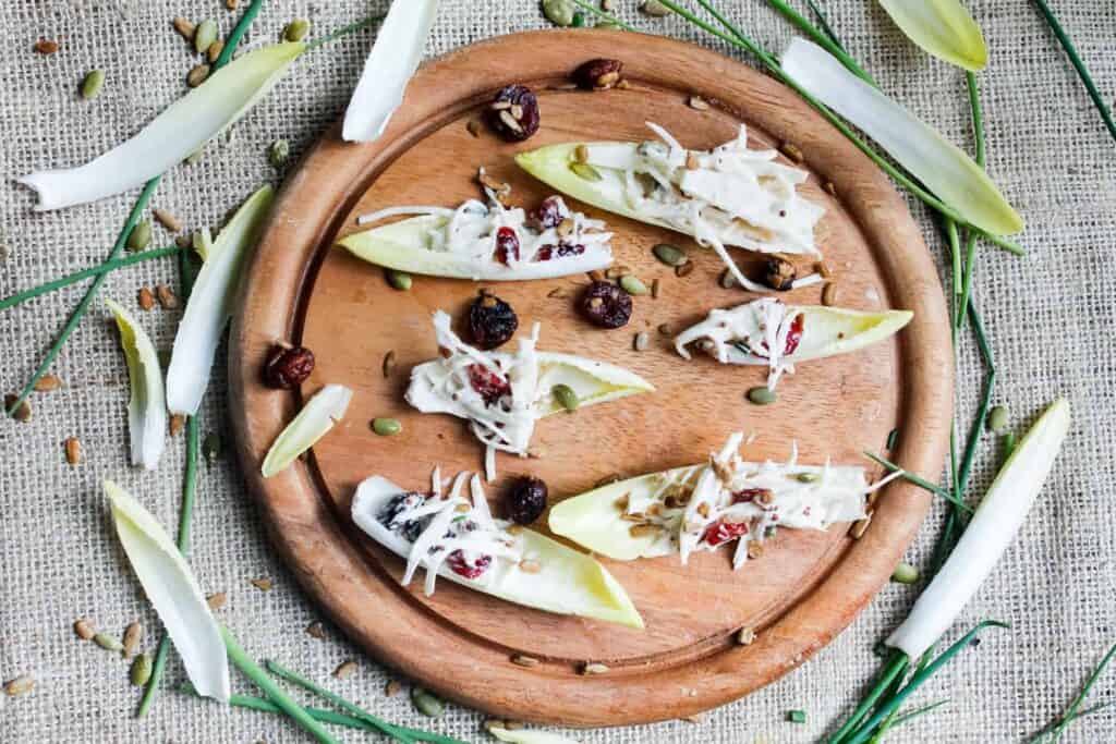 Studded with dried cranberries and pepitas & covered in a beautiful, tangy sauce, these endive spears with celery root remoulade are a great GF appetizer. Gluten-free, paleo, vegan option.