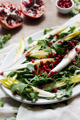Endive and arugula provide the peppery bite to this arugula salad, while the milky fresh mozzarella brings creaminess, & the pomegranate and pecans the pop.