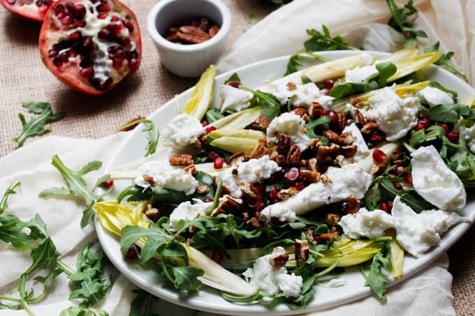 Endive and arugula provide the peppery bite to this arugula salad, while the milky fresh mozzarella brings creaminess, & the pomegranate and pecans the pop.