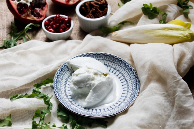 Endive and arugula provide the peppery bite to this arugula salad, while the milky fresh mozzarella brings creaminess, & the pomegranate and pecans the pop.