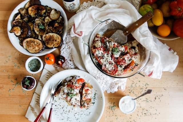 A lightened up version of a classic, this cold moussaka is layered with eggplant, potatoes and tomatoes, and served with tangy kalamata feta sauce.