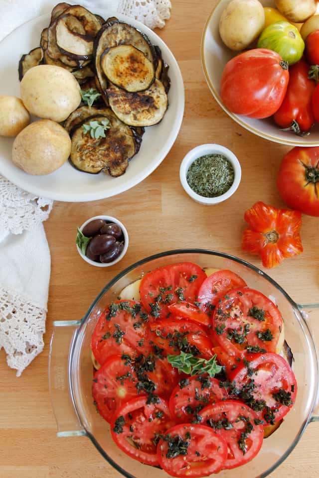 A lightened up version of a classic, this cold moussaka is layered with eggplant, potatoes and tomatoes, and served with tangy kalamata feta sauce.