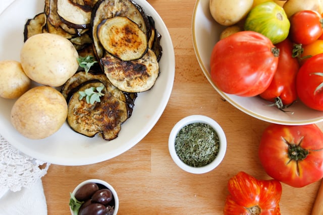 A lightened up version of a classic, this cold moussaka is layered with eggplant, potatoes and tomatoes, and served with tangy kalamata feta sauce.