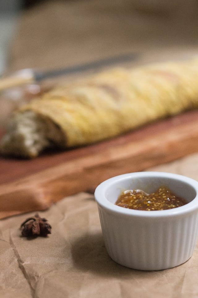 A loaf of bread next to a bowl of ground cherry jam.