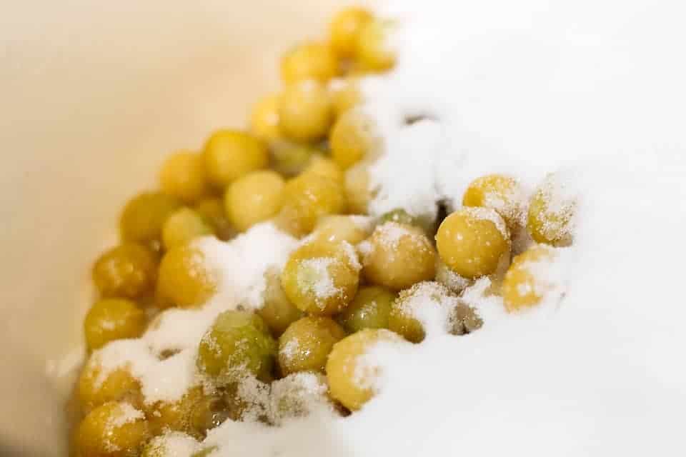 A bowl full of ground cherries covered in snowy ground cherry jam.