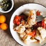 Roasted cauliflower with tomatoes and capers is caramelized, rich in flavour and glistening with sauce, a perfect dish to welcome you home or whip up on a weeknight.