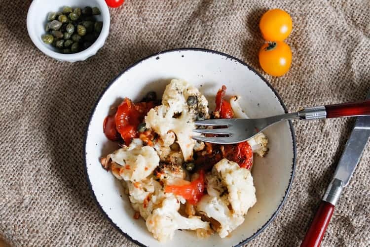 Roasted cauliflower with tomatoes and capers is caramelized, rich in flavour and glistening with sauce, a perfect dish to welcome you home or whip up on a weeknight.