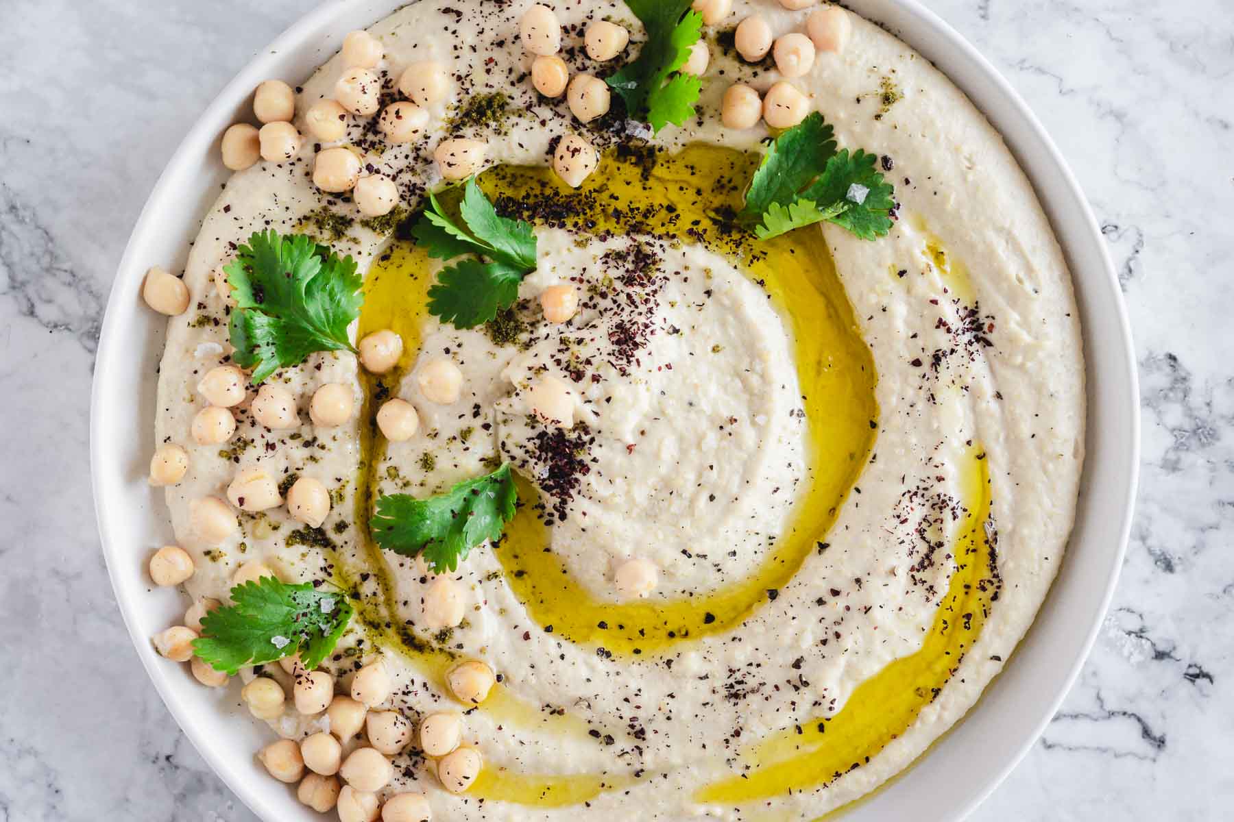 close up on hummus with parsley and chickpeas