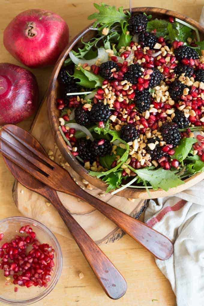 Berry salad with red onions, arugula, nuts and pomegranate arils