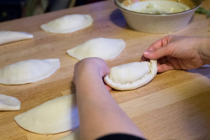 hands rolling empanadas