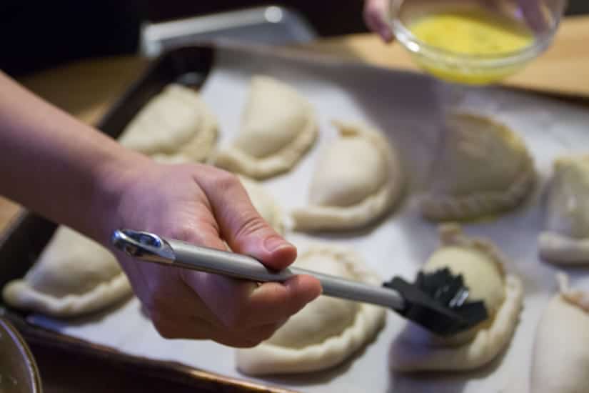 brushing empanadas with egg wash