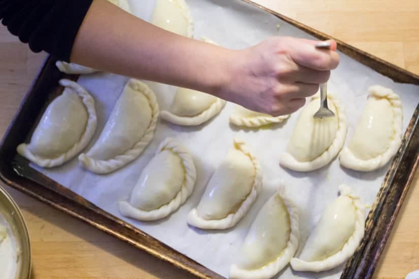 pricking empanadas with fork