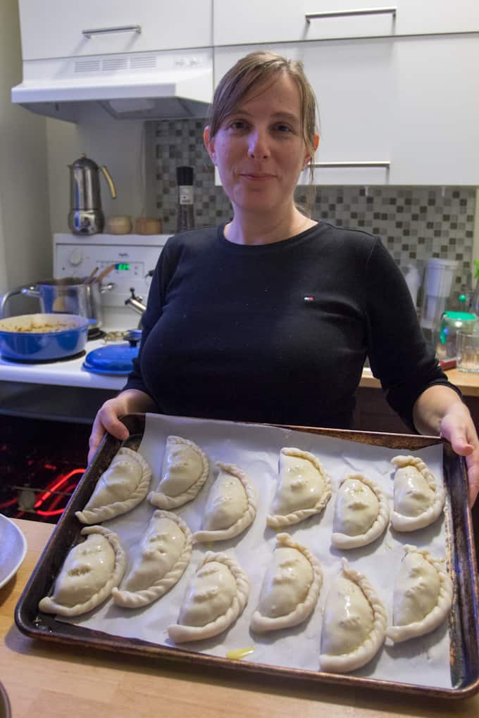 Girl with baking sheet of empanadas