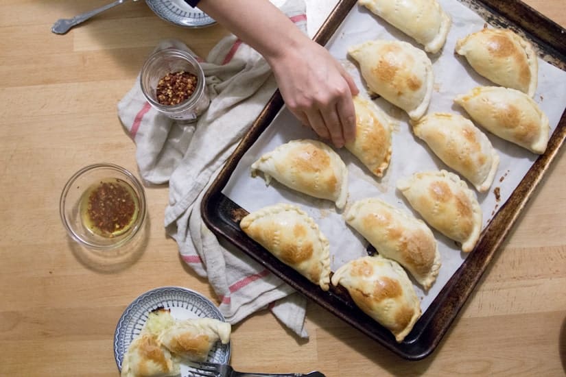 hand taking an empanada