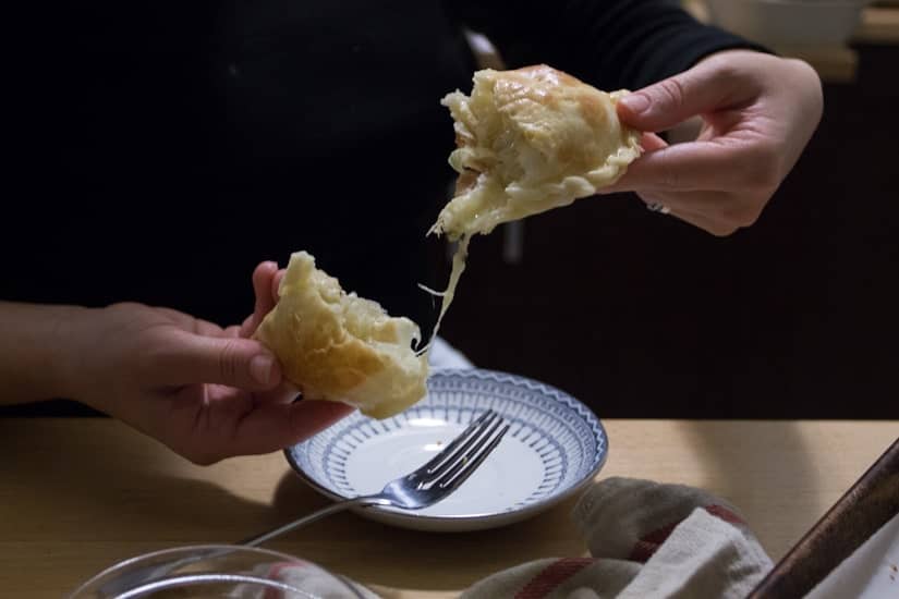 ripping cheese empanada in half