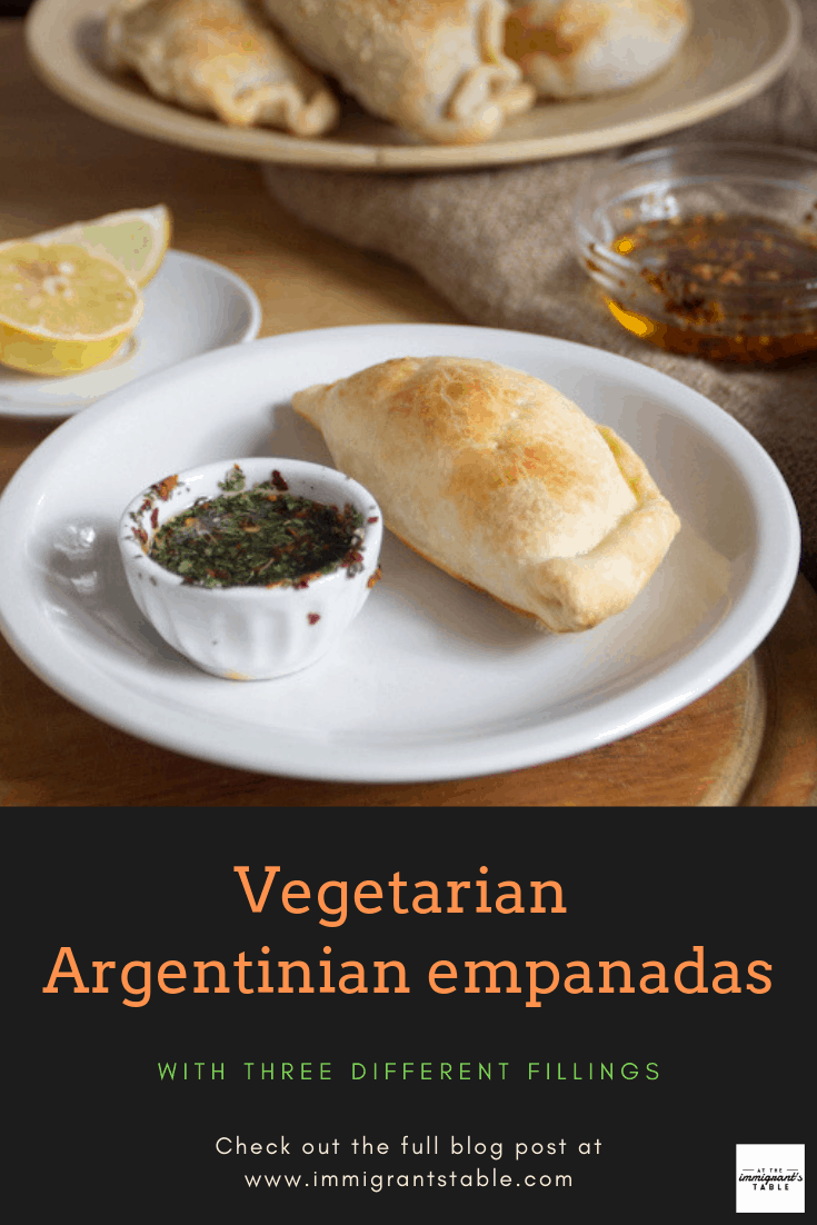 Argentinian empanada on a plate with chimichurri dipping sauce and more empanadas in the background