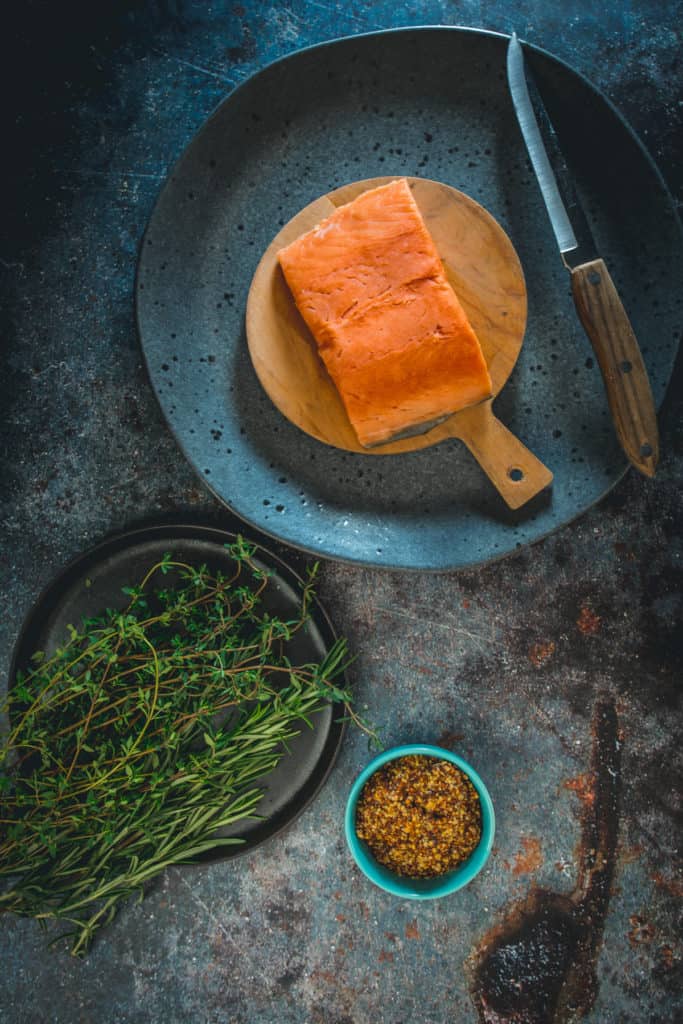 ingredients on plates: Sockeye salmon, herbs and mustard