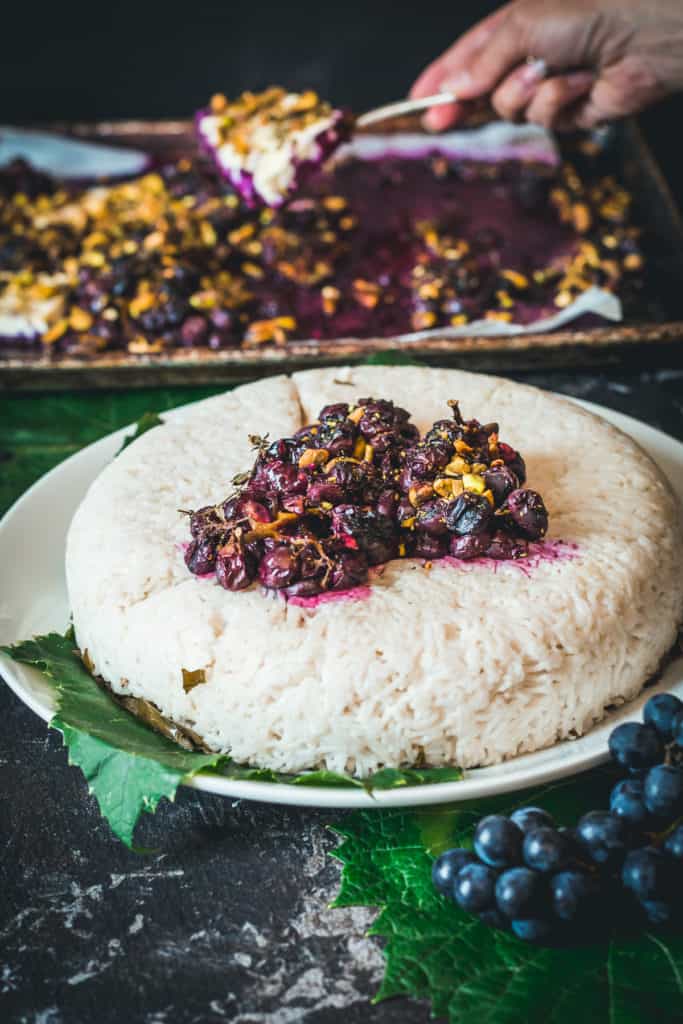 Rice topped with cooked grape sauce and pistachios