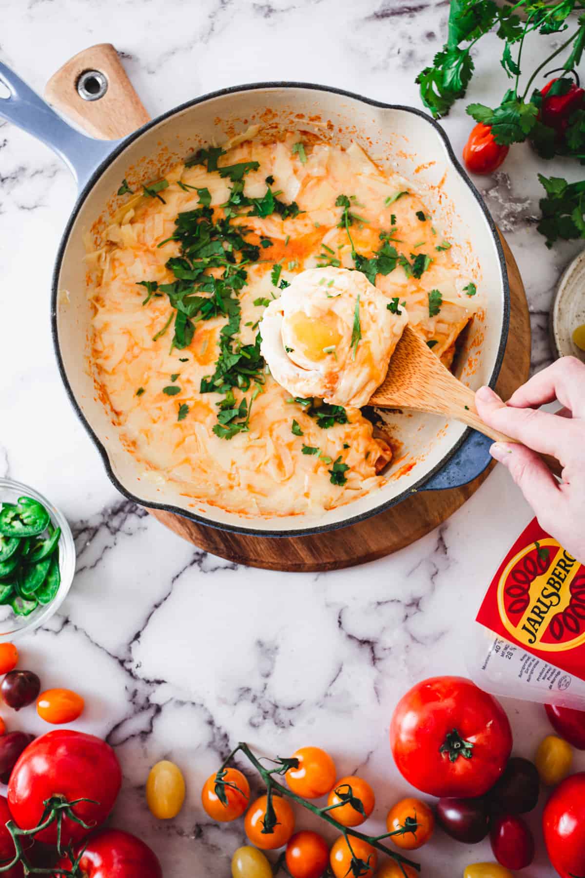 lifting spoon from cheese shakshuka with cilantro