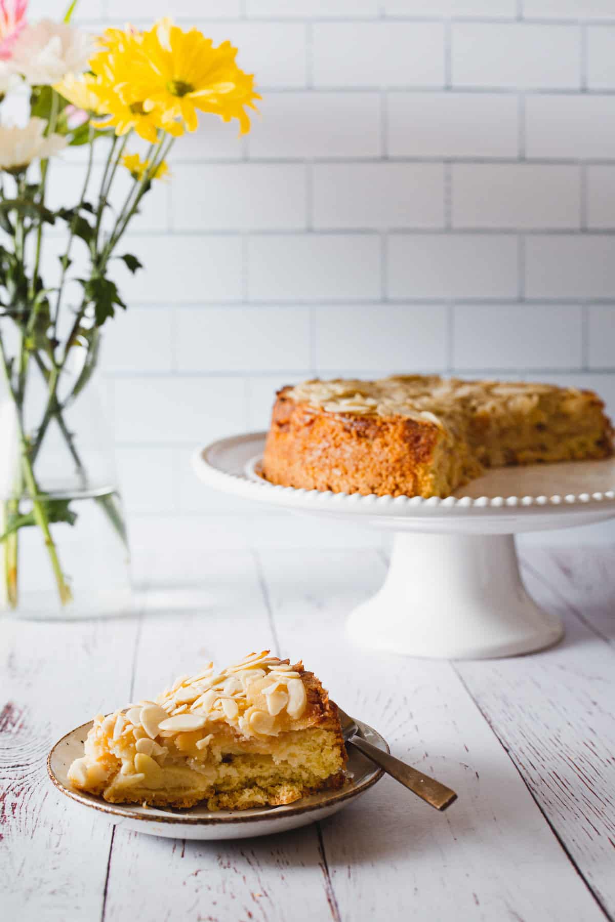 apple cake slice against apple cake in background