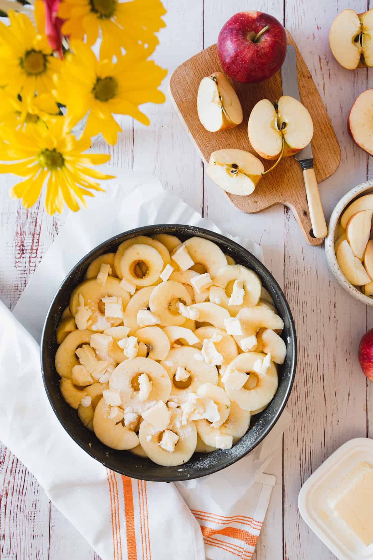 apples in cake pan with butter dotting