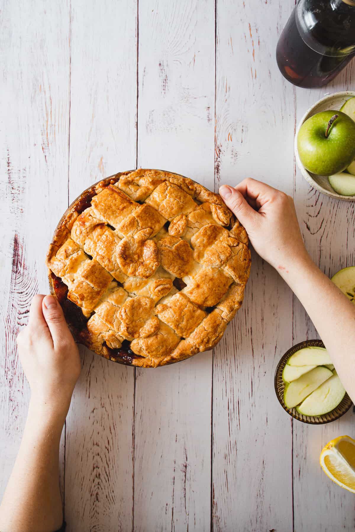 hands holding baked gluten free apple pie