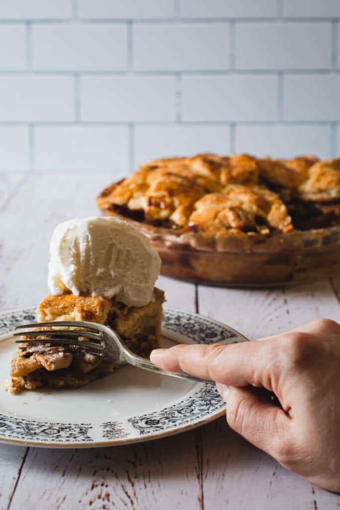 cutting into a slice of apple pie with ice cream