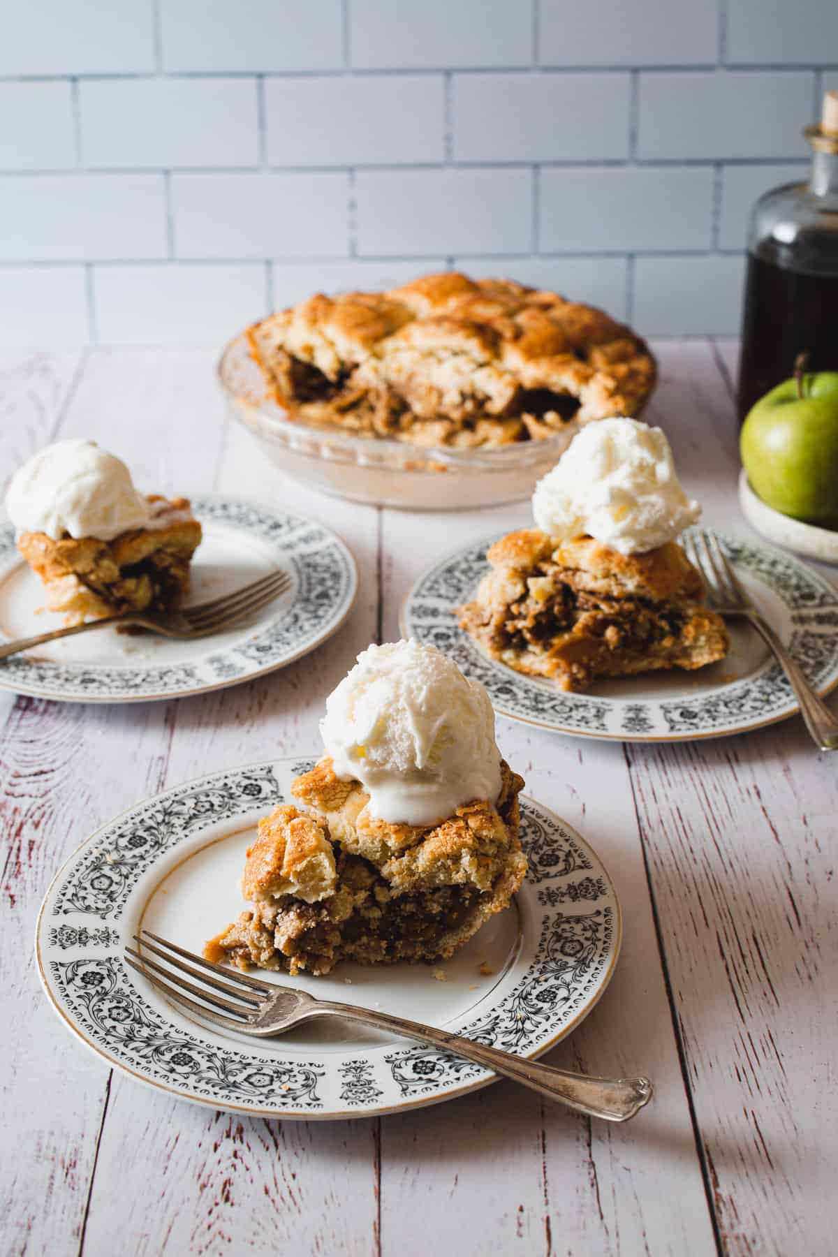 three slices of cutting into a slice of gluten free apple pie with ice cream