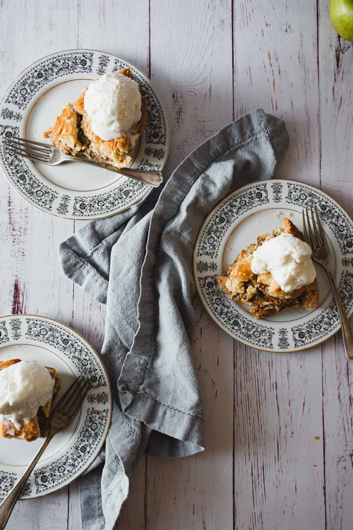 three slices of cutting into a slice of gluten free apple pie with ice cream