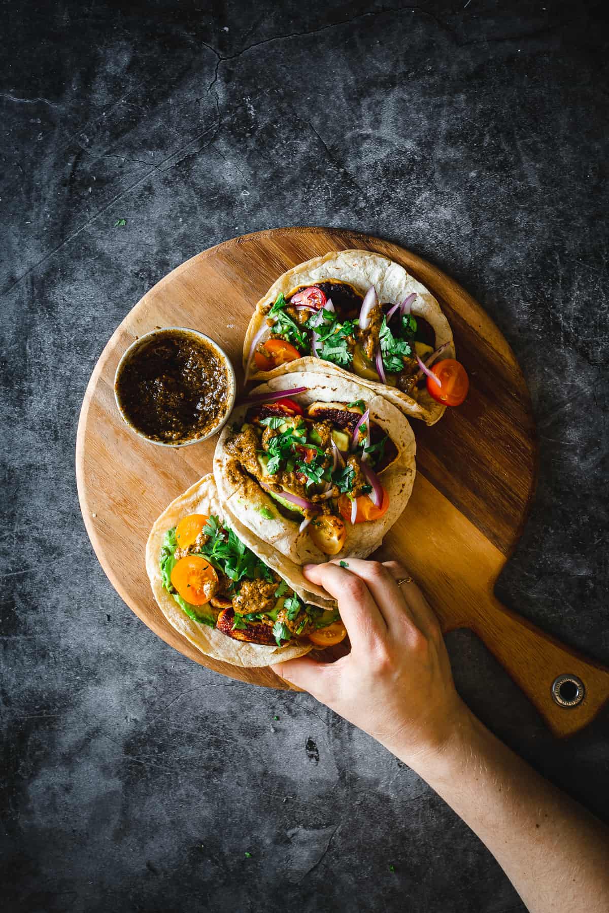 hand grabbing halloumi tacos