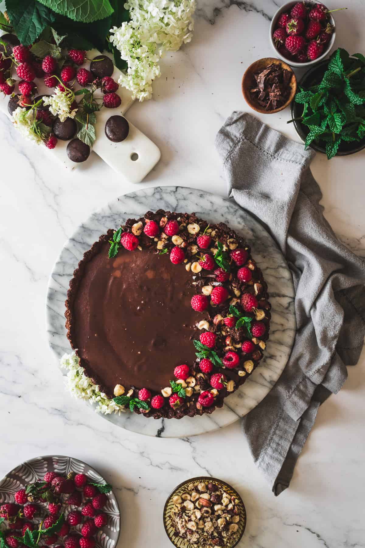 low carb chocolate raspberry tart with little bowls of toppings