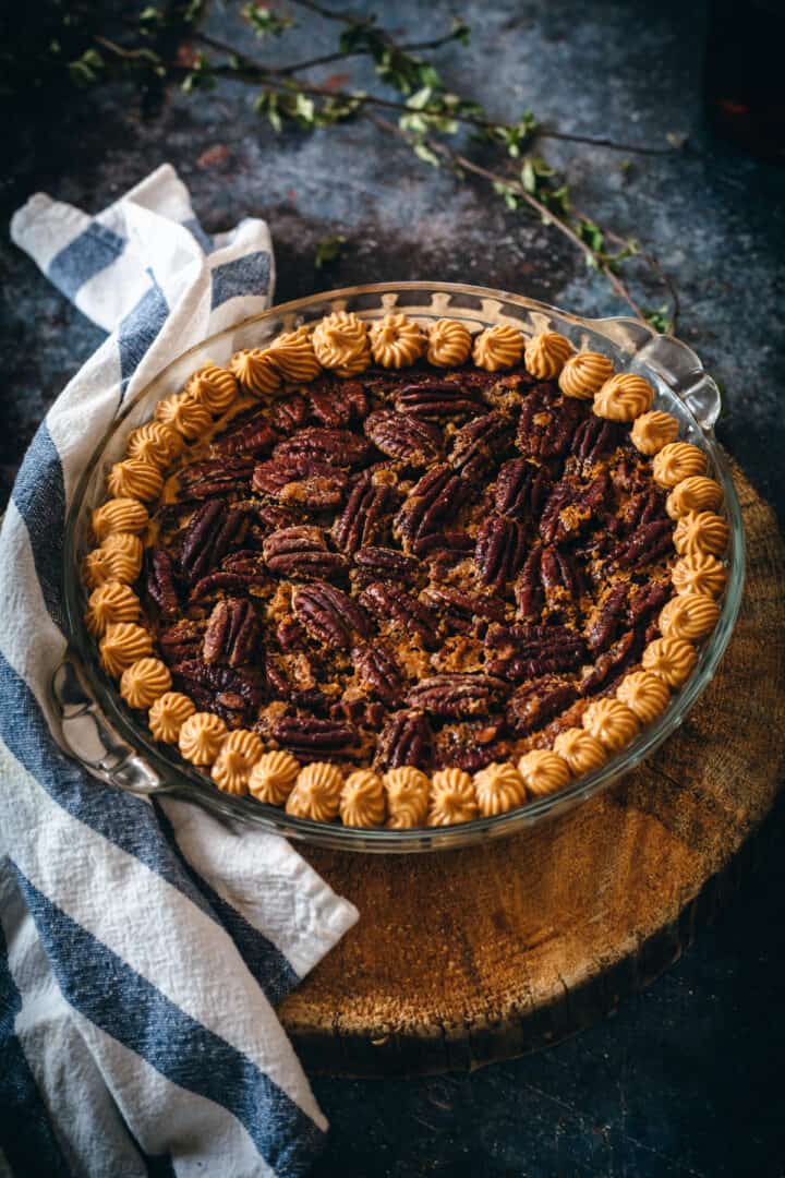 baked gluten free pecan pie decorated with maple dulce de leche piping