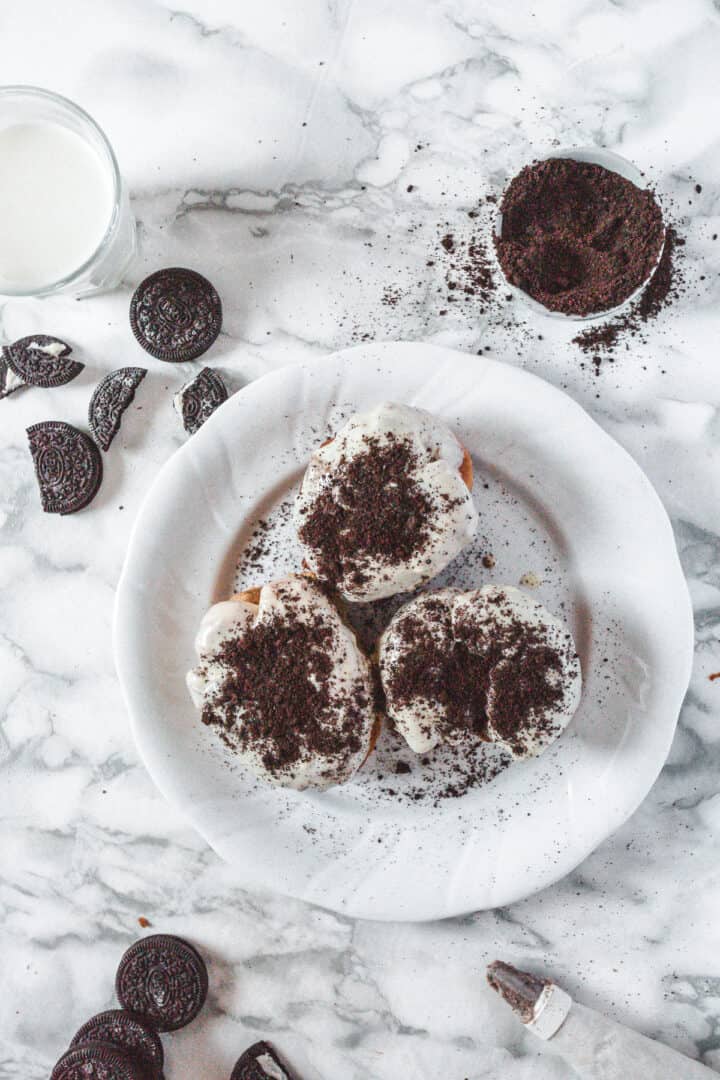 3 Oreo sufganiyot on a plate surrounded by ingredients