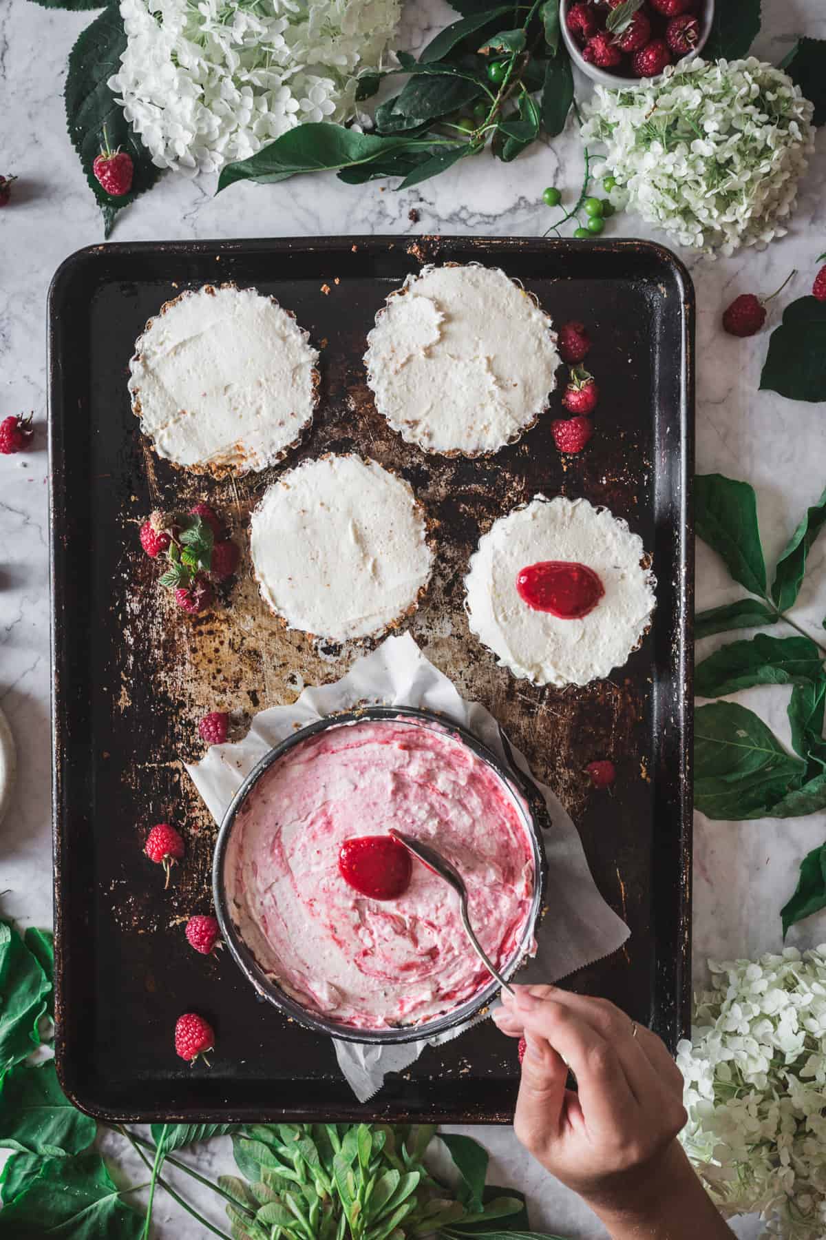 dropping raspberry swirl on cheesecake top