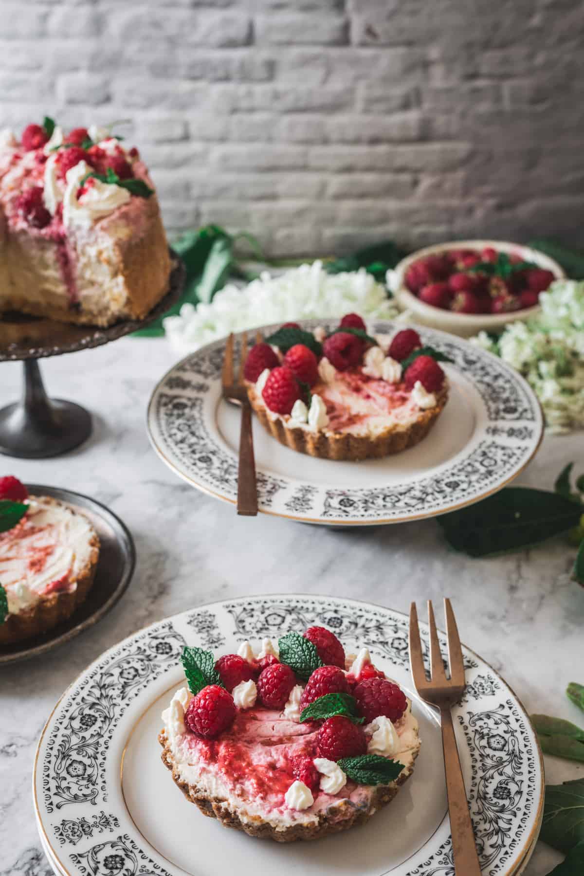 close up on individual magical keto cheesecake with raspberries and two in the background