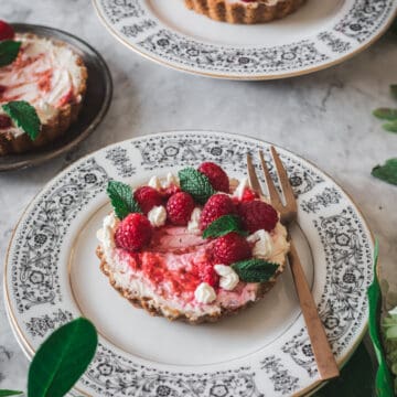 close up on individual magical keto cheesecake with raspberries and one in the background