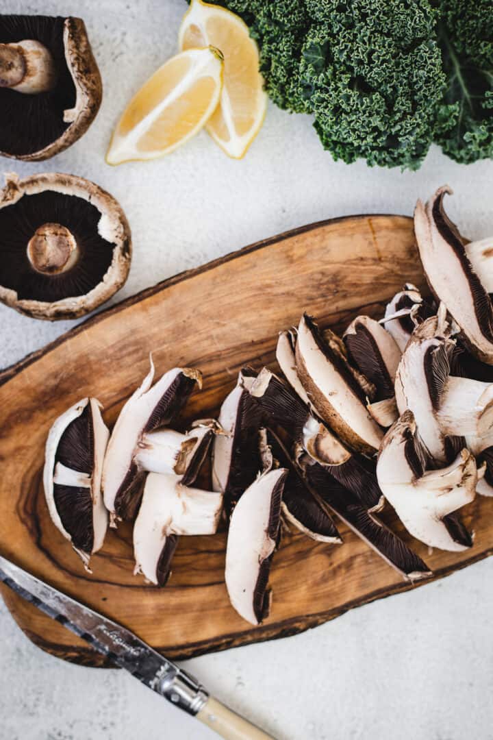 slicing portobello mushrooms on cutting board