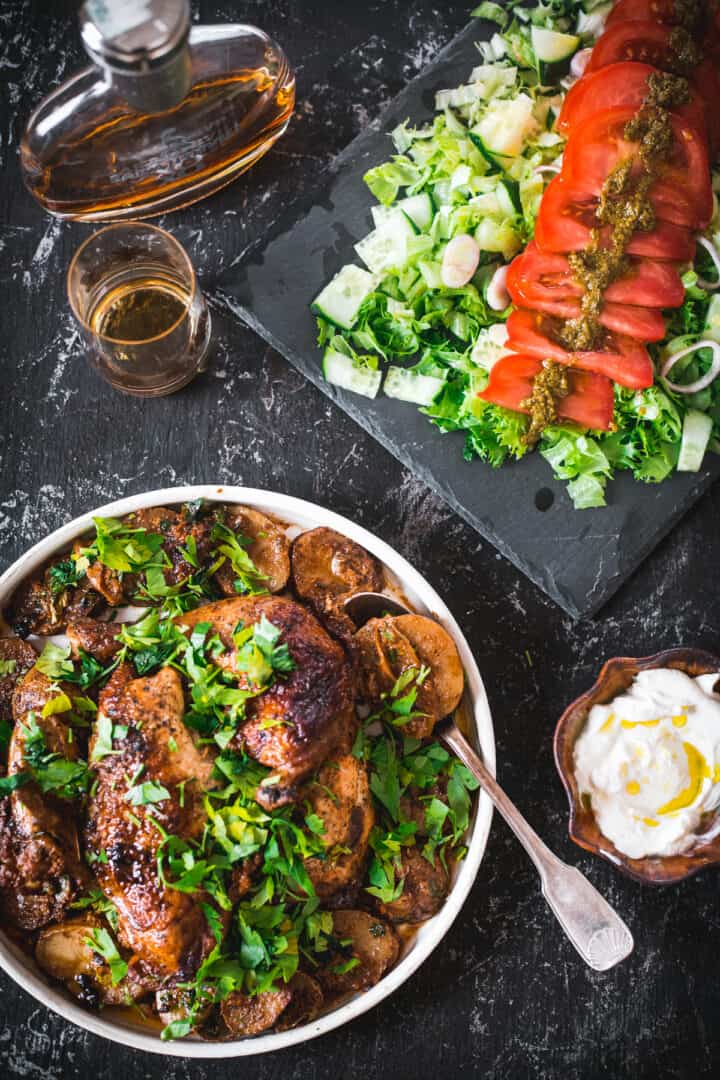 baked buttermilk chicken and potatoes platter with serving spoon, brandy and salad