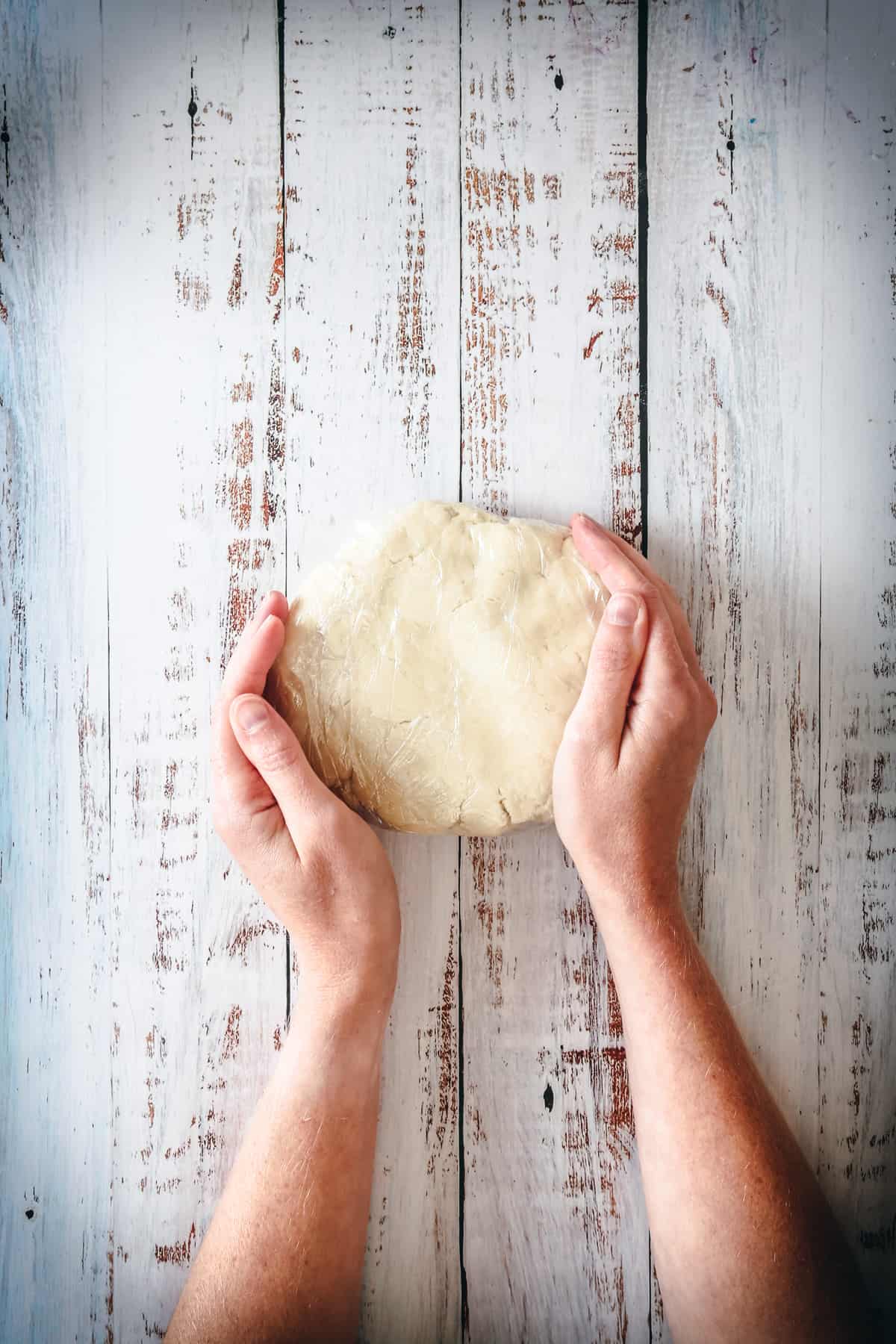 hands holding chilled gluten free galette dough