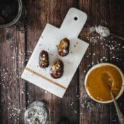 dates stuffed with almond butter on cutting board