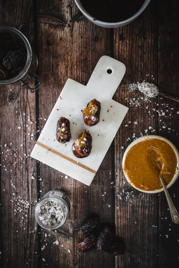 dates stuffed with almond butter on cutting board